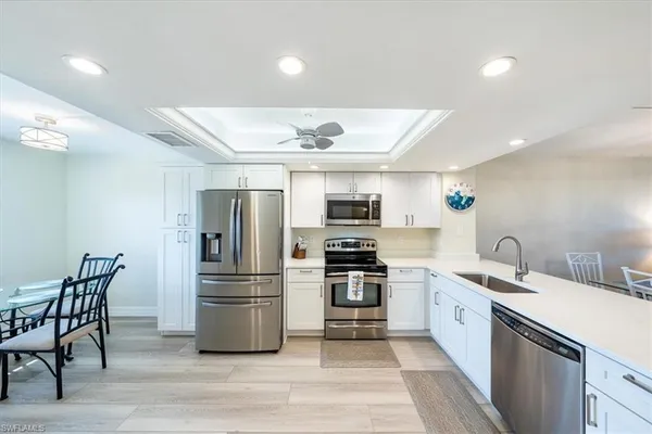 a kitchen with stainless steel appliances granite countertop a refrigerator and a stove top oven
