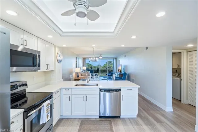 a kitchen with a sink stainless steel appliances a counter space and cabinets