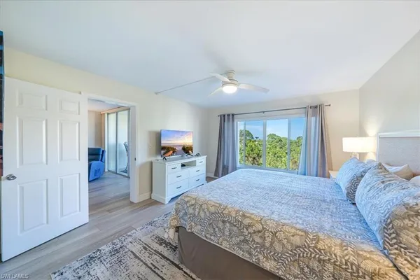 a large bedroom with a bed and a flat screen tv