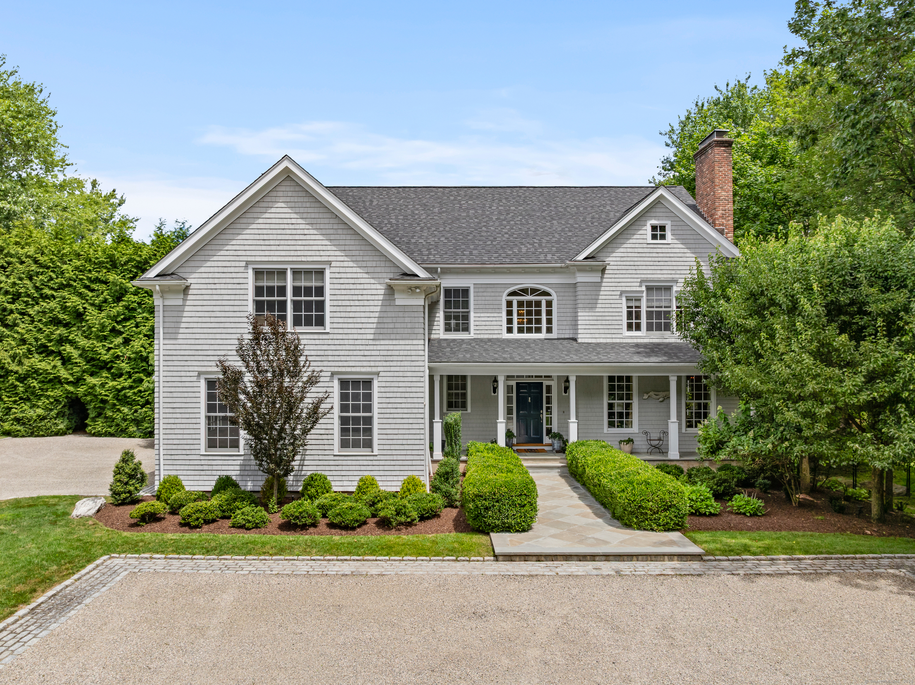 a front view of a house with a yard and trees
