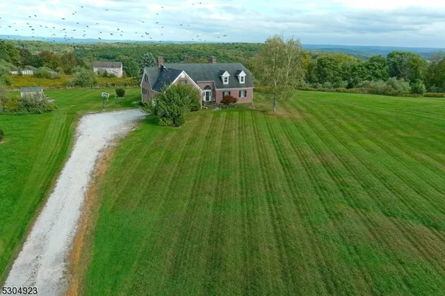 a view of a house with a big yard and large trees