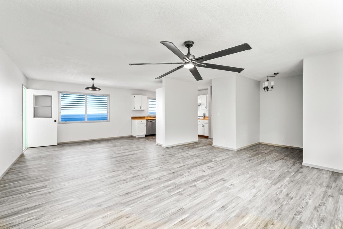 88-2259 Milolii Road Captain Cook, HI 96704 - Photo 14 of 30 an empty room with wooden floor a ceiling fan and windows