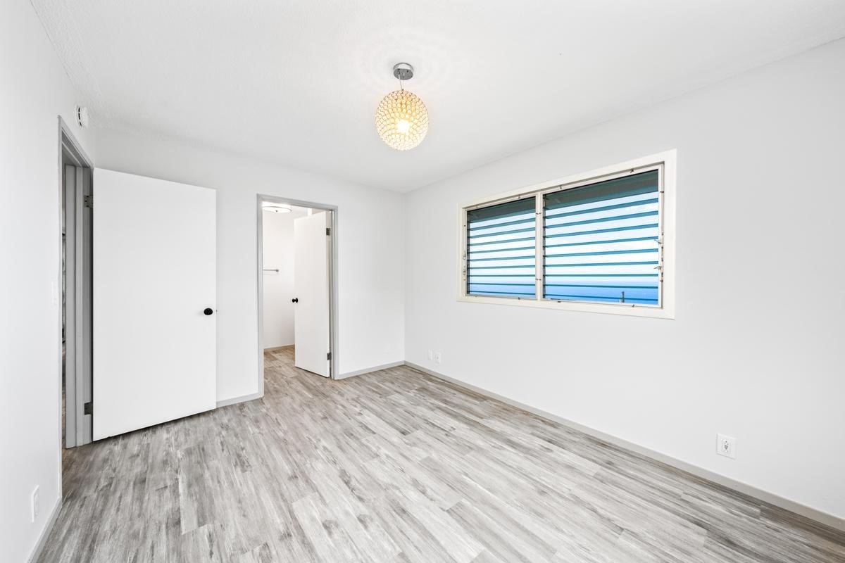 88-2259 Milolii Road Captain Cook, HI 96704 - Photo 23 of 30 an empty room with wooden floor and windows