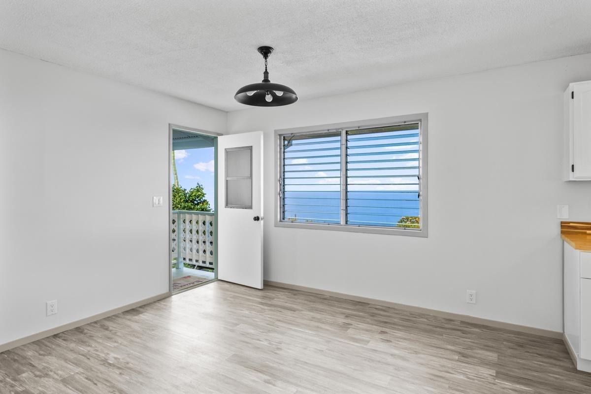 88-2259 Milolii Road Captain Cook, HI 96704 - Photo 25 of 30 a view of an empty room with a window and wooden floor