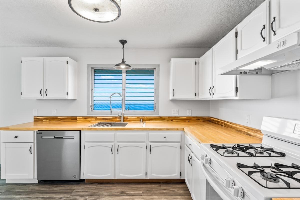 88-2259 Milolii Road Captain Cook, HI 96704 - Photo 4 of 30 a kitchen with stainless steel appliances granite countertop a sink stove and cabinets