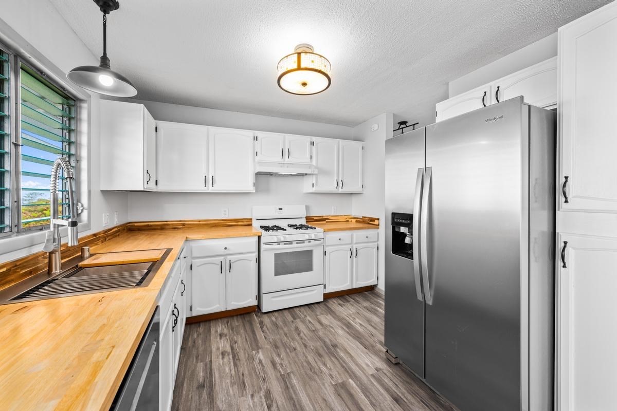 88-2259 Milolii Road Captain Cook, HI 96704 - Photo 9 of 30 a kitchen with a refrigerator and a sink