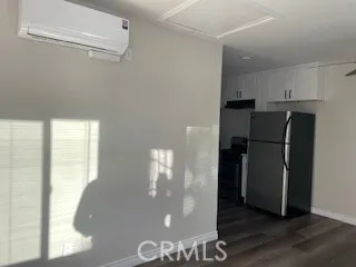 a view of a kitchen with a refrigerator wooden floor and a kitchen
