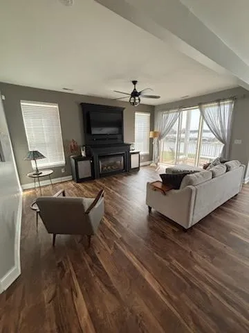 a living room with furniture a flat screen tv and a large window
