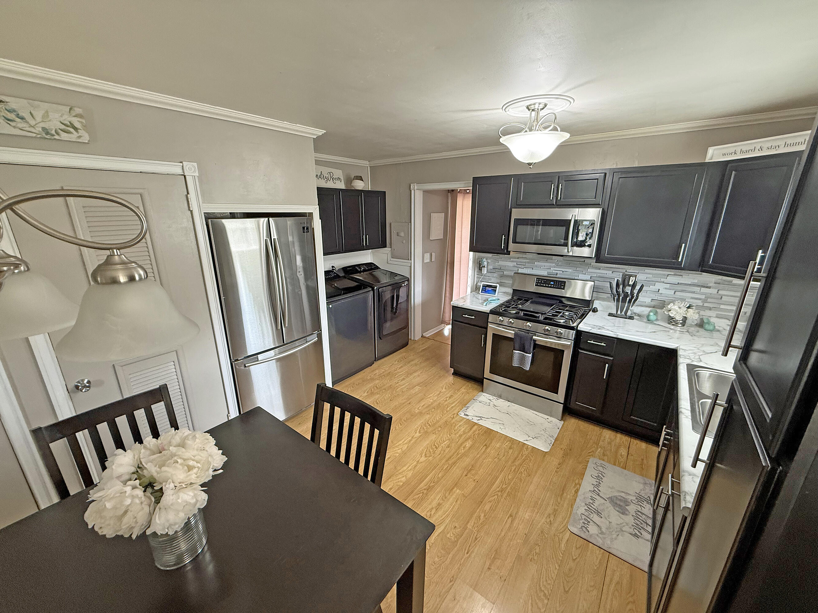 3718 173rd Court Hammond, IN 46323 - Photo 8 of 30 a kitchen with stainless steel appliances granite countertop a refrigerator a stove a sink dishwasher a dining table and chairs with wooden floor