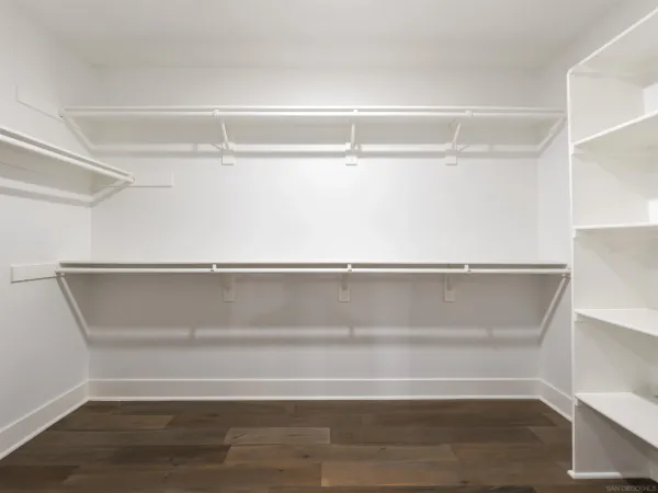 a view of walk in closet with empty racks