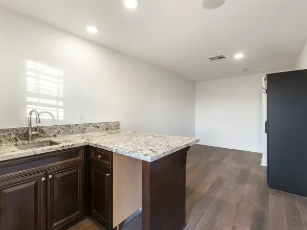 a utility room with a sink a cabinetry and wooden floor