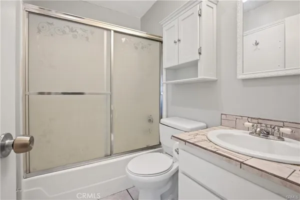 a bathroom with a granite countertop sink toilet and a mirror