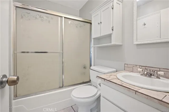 a bathroom with a granite countertop sink toilet and a mirror