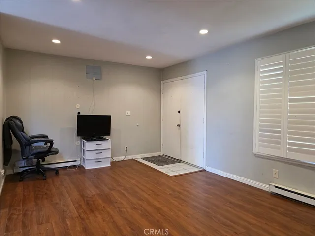 a view of room with wooden floor and furniture