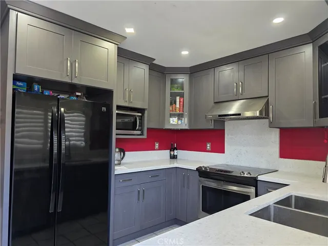a kitchen with stainless steel appliances granite countertop a refrigerator stove and sink