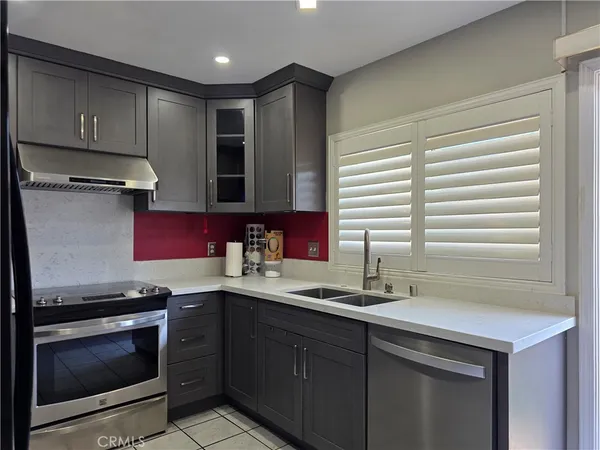 a kitchen with stainless steel appliances granite countertop a sink stove and cabinets