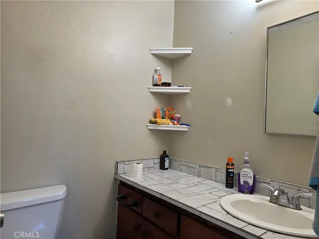 a bathroom with a sink a toilet and a mirror