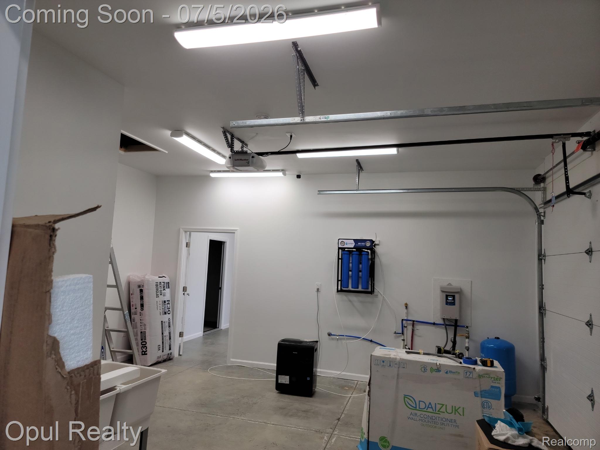 7503 Reading Road East Pittsford, MI 49271 - Photo 11 of 24 Brightly lit garage space featuring a concrete floor, white painted walls, and an overhead garage door