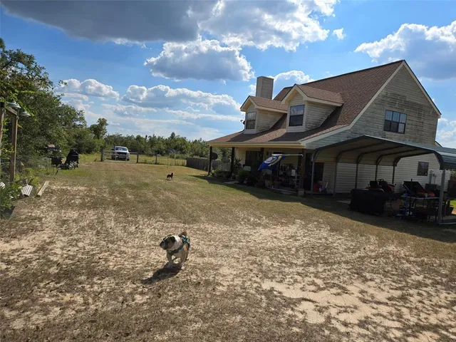 a view of a house with backyard and sitting area