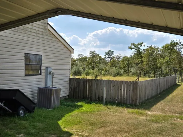 a view of a white house with a large window and wooden floor