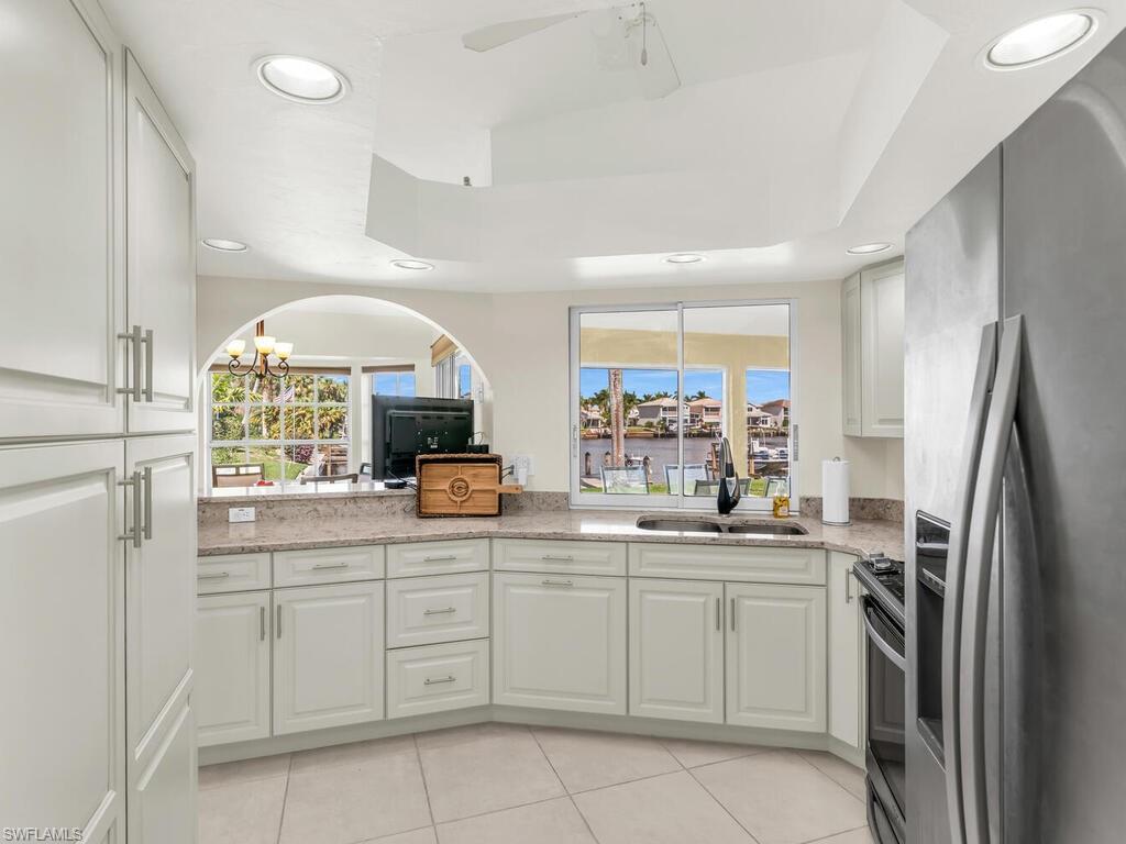 111 Morning Star Cay Naples, FL 34114 - Photo 12 of 47 a kitchen with white cabinets and sink
