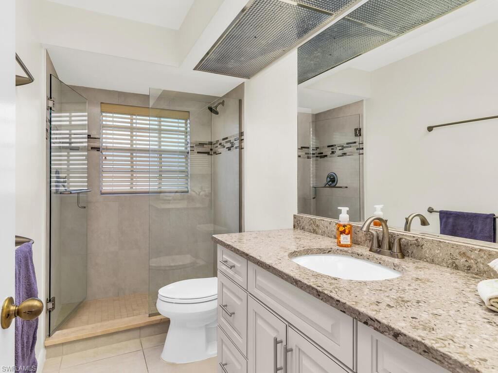 111 Morning Star Cay Naples, FL 34114 - Photo 21 of 47 a bathroom with a granite countertop sink toilet and shower