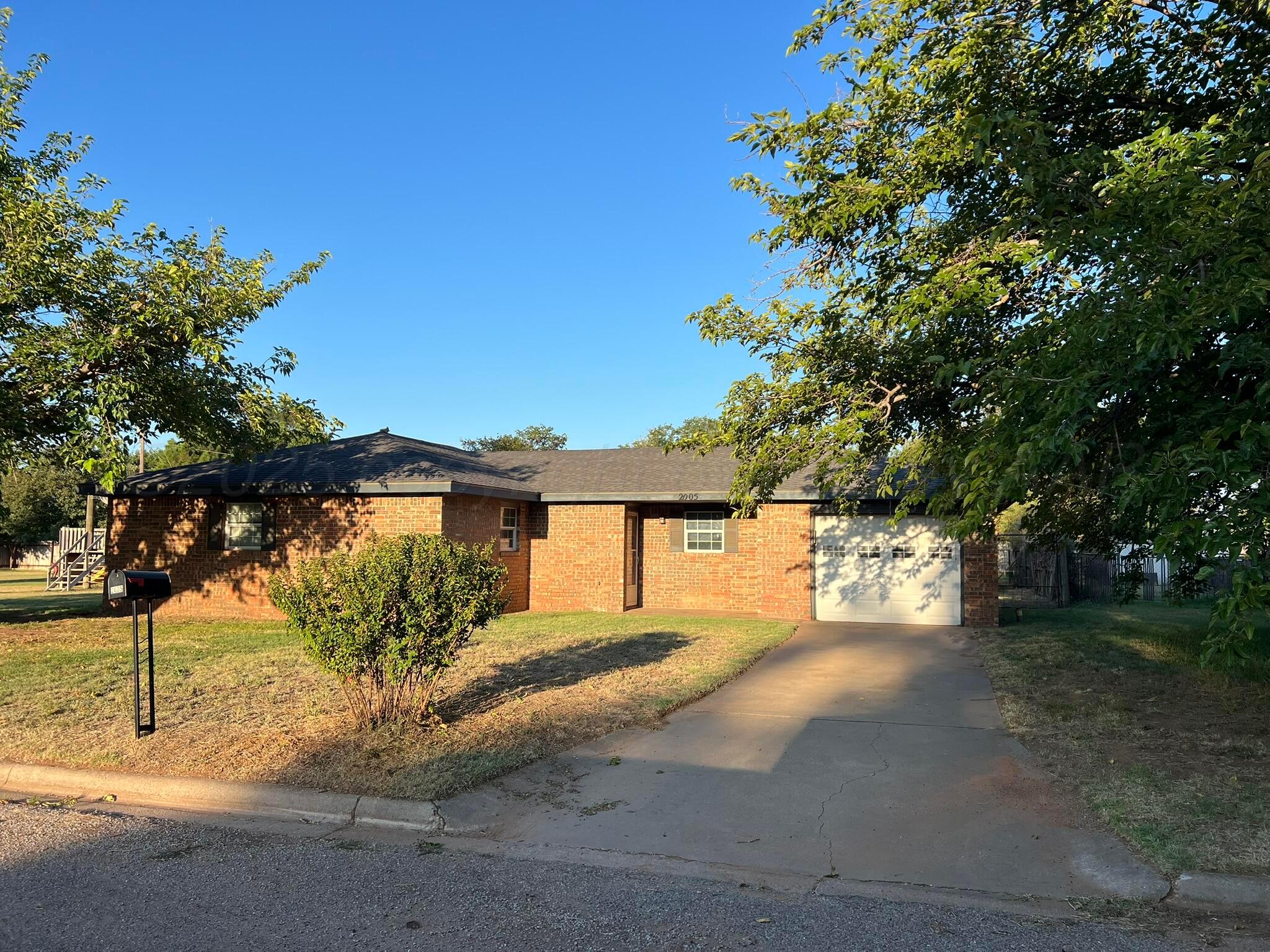 2005 North 20th Street Memphis, TX 79245 - Photo 1 of 19 a front view of a house with a yard and garage