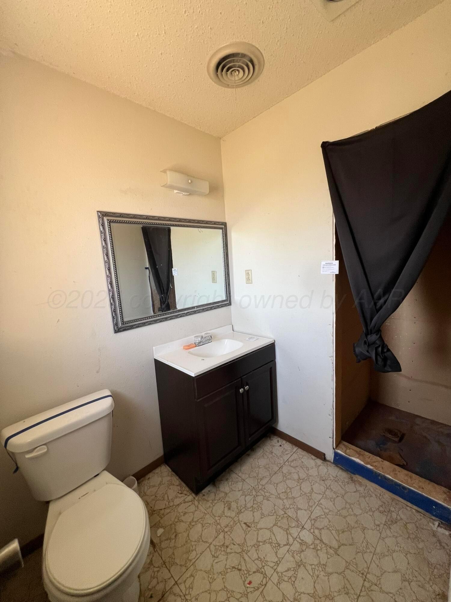 2005 North 20th Street Memphis, TX 79245 - Photo 12 of 19 a bathroom with a toilet sink and mirror