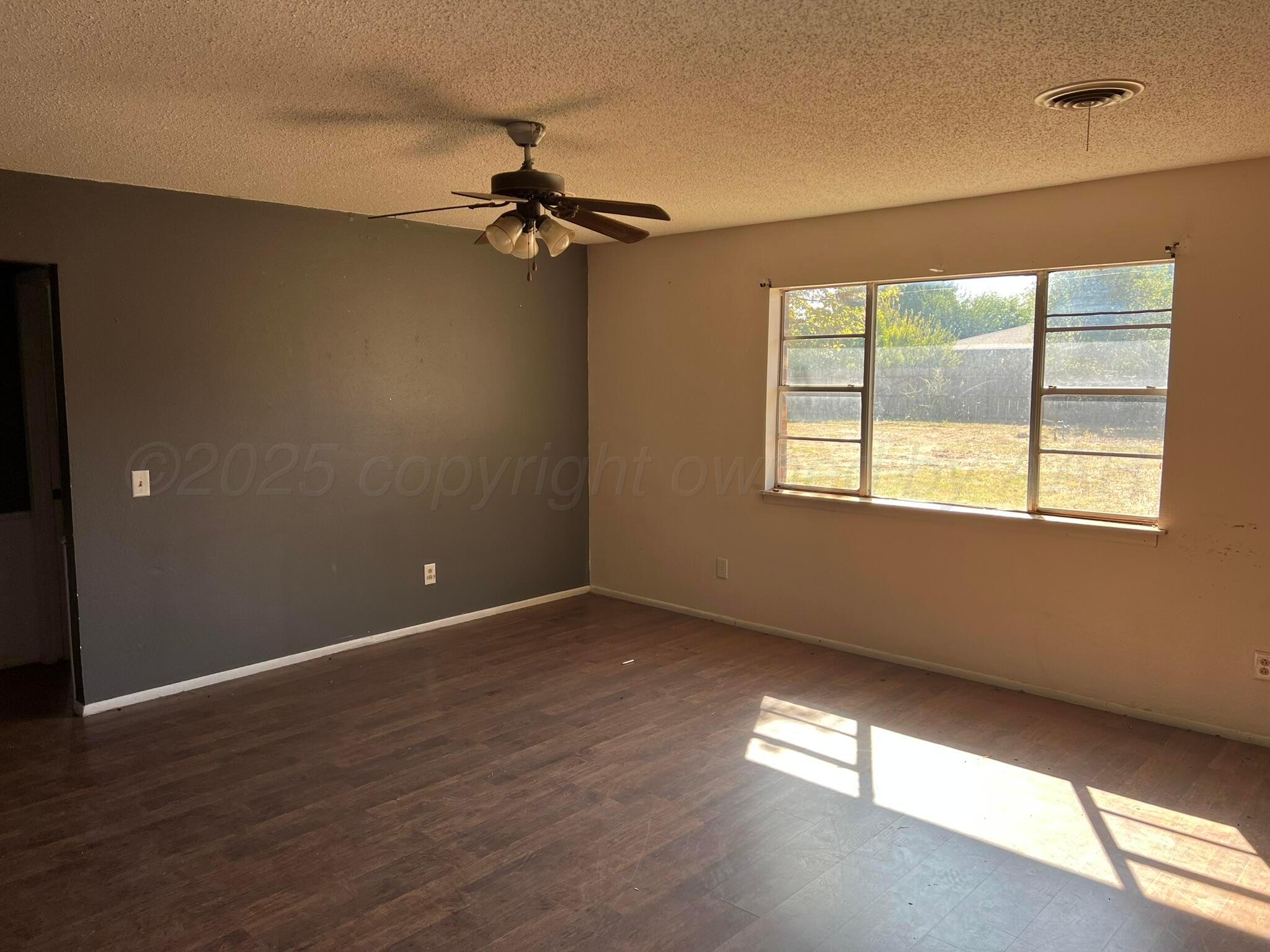 2005 North 20th Street Memphis, TX 79245 - Photo 4 of 19 a view of an empty room with a window and wooden floor