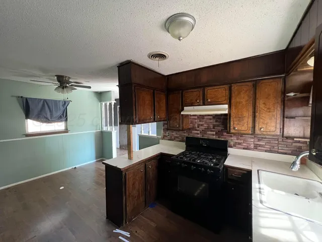 a kitchen with granite countertop a stove and a sink