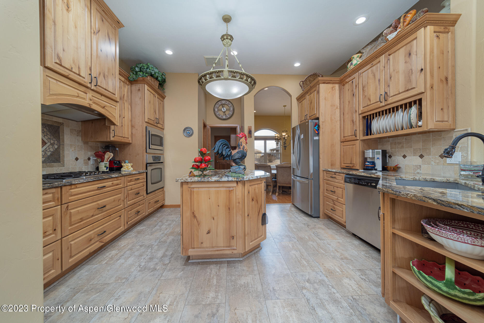 685 Roundup Drive Grand Junction, CO 81507 - Photo 14 of 39 a kitchen with stainless steel appliances kitchen island granite countertop a stove a sink and a refrigerator