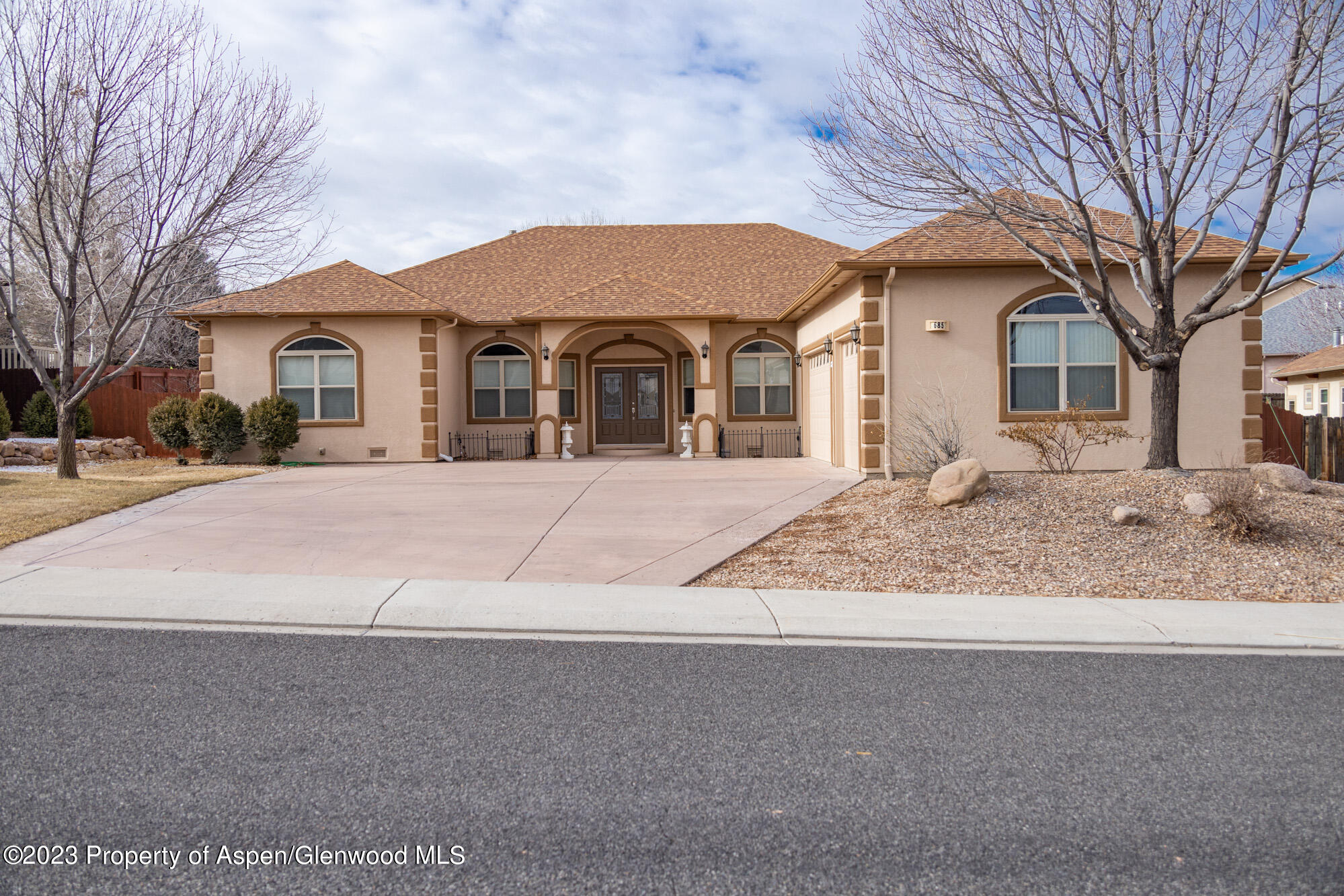 685 Roundup Drive Grand Junction, CO 81507 - Photo 4 of 39 a front view of a house with a yard covered in snow