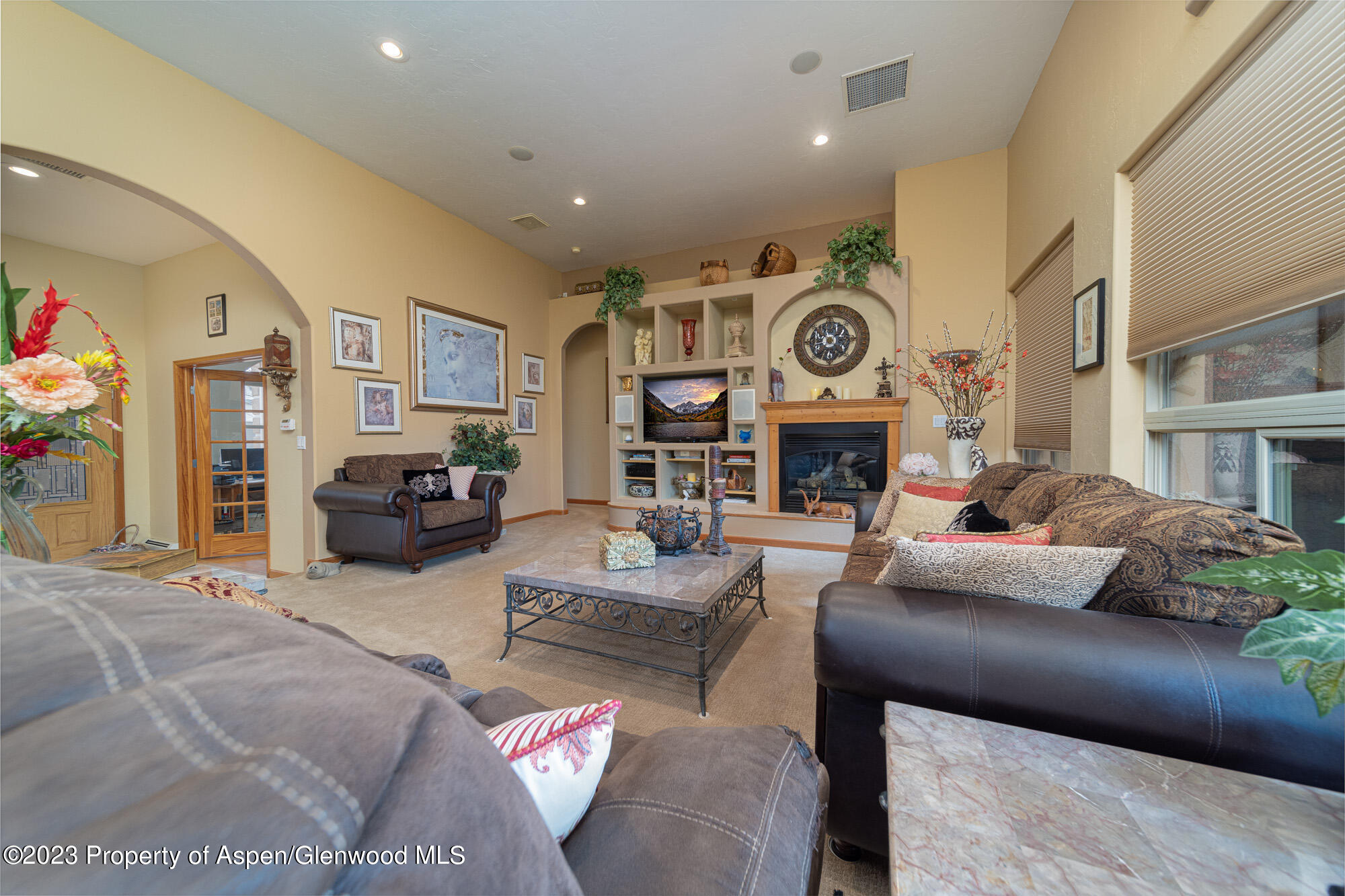 685 Roundup Drive Grand Junction, CO 81507 - Photo 8 of 39 a living room with furniture a fireplace and a flat screen tv