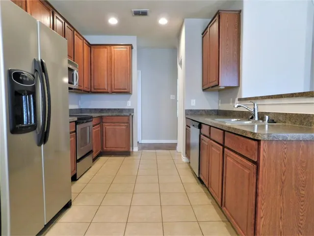 a kitchen with stainless steel appliances granite countertop a stove microwave and refrigerator