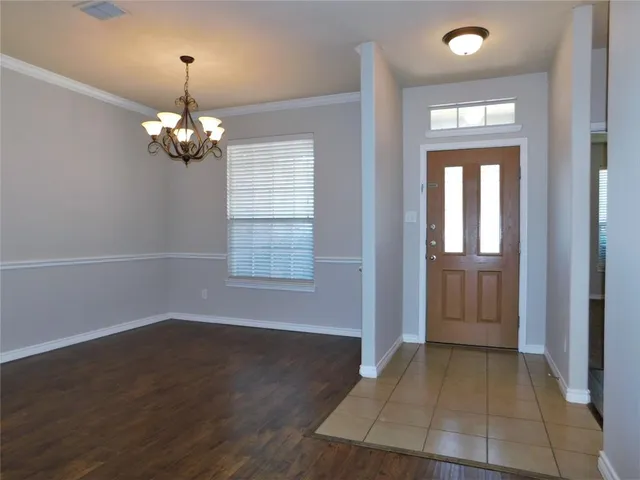 a view of a kitchen with a fridge and wooden floor