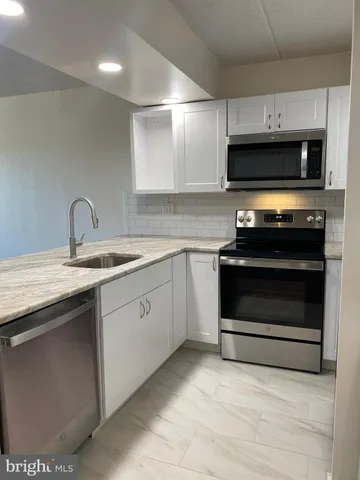 a kitchen with stainless steel appliances a stove a microwave and a refrigerator