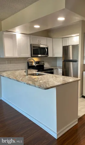 a view of big room with wooden floor and windows