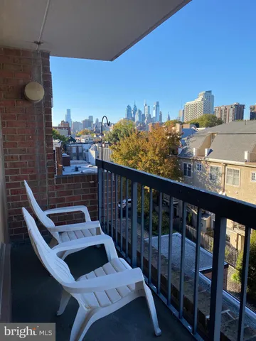 a view of kitchen and empty room with wooden floor