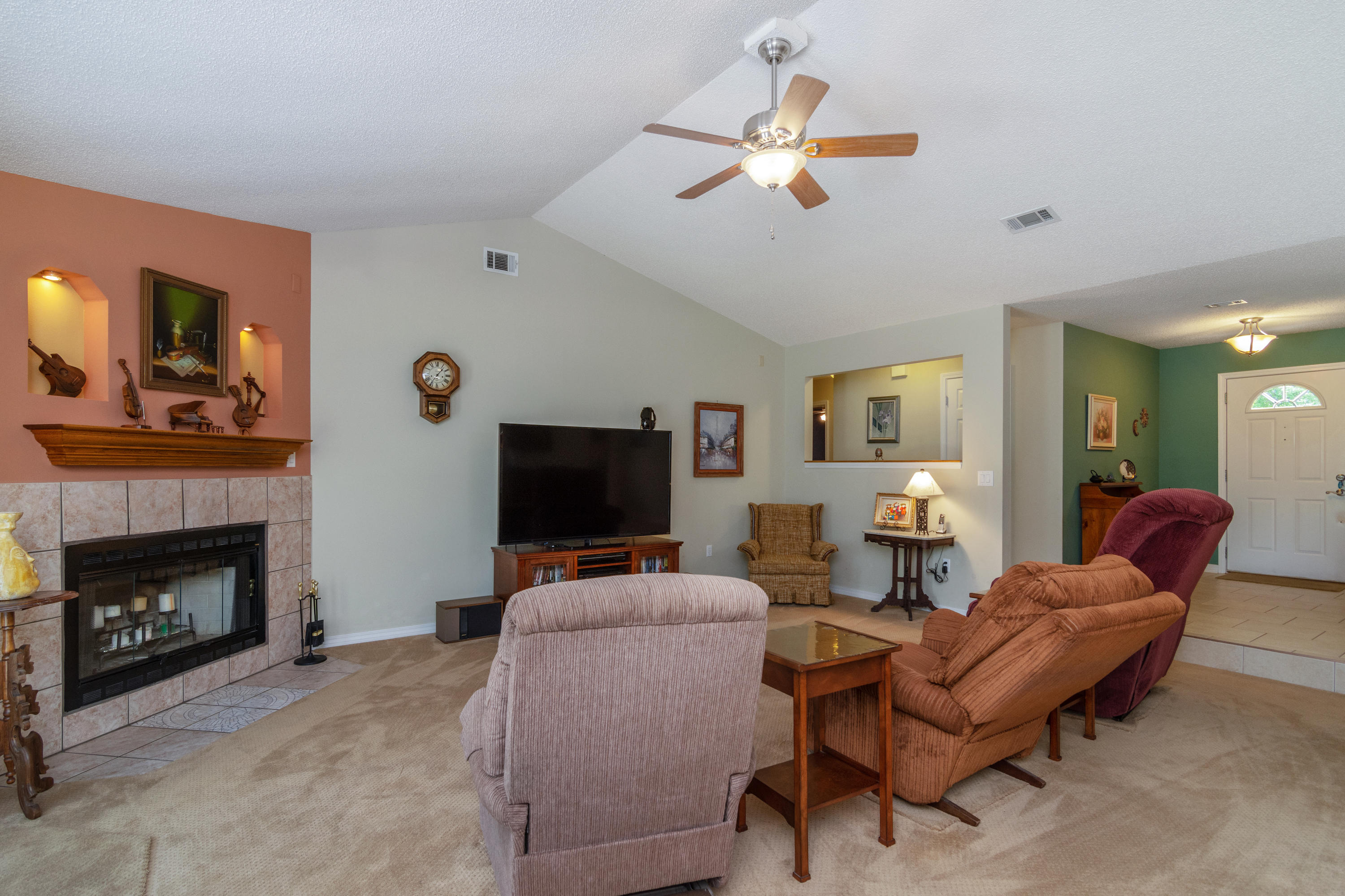 6151 Beasley Road Crestview, FL 32536 - Photo 18 of 49 a living room with furniture a fireplace and a flat screen tv