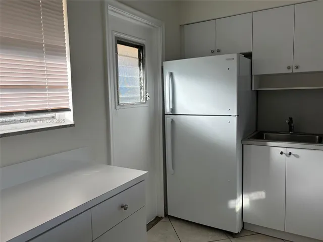 a white refrigerator freezer and a stove sitting inside of a kitchen