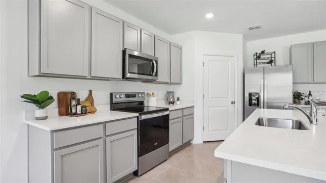 a kitchen with stainless steel appliances granite countertop a sink a stove and cabinets