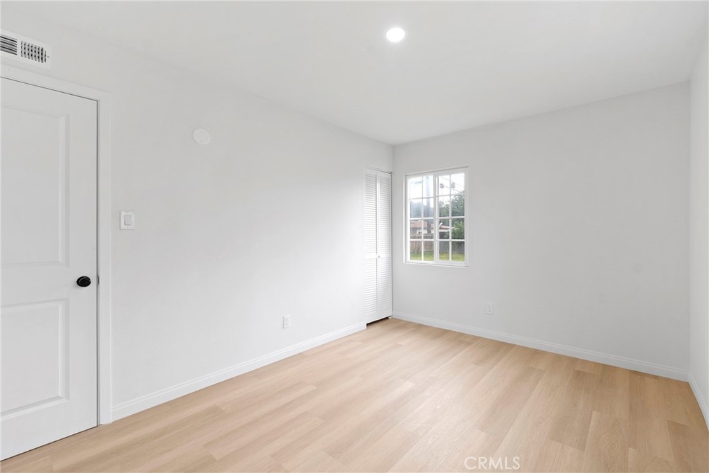 5847 Meadowbrook Lane Riverside, CA 92504 - Photo 23 of 31 a view of an empty room with wooden floor and a window