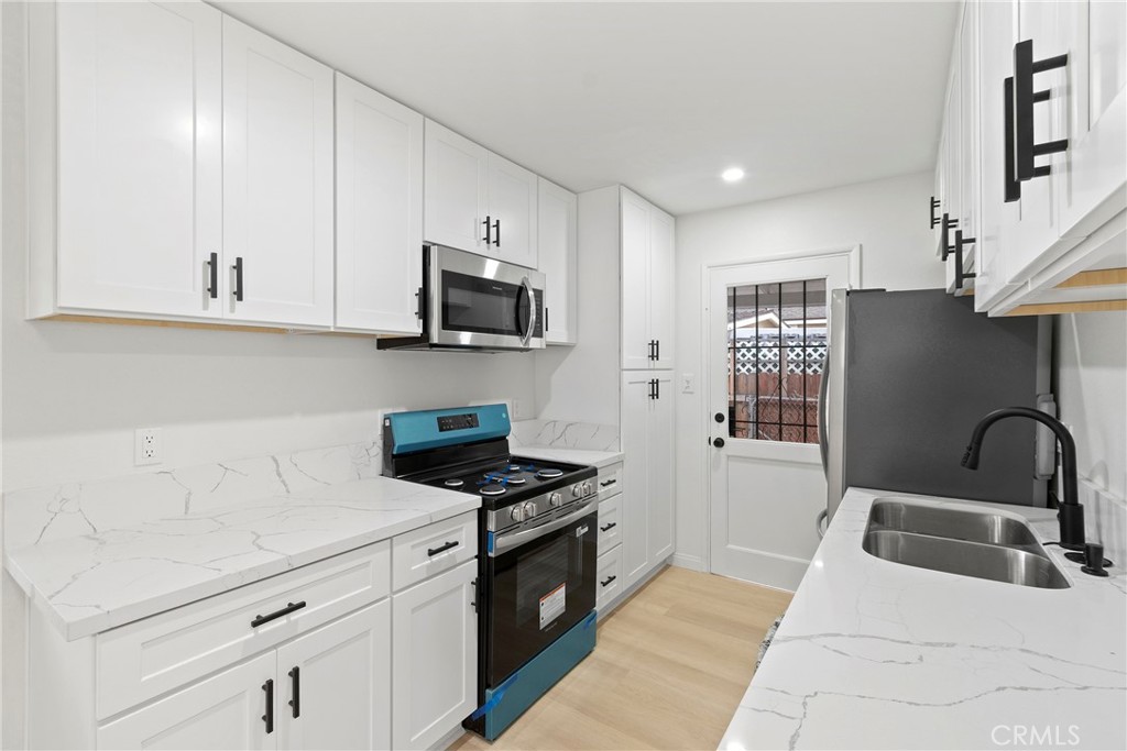 5847 Meadowbrook Lane Riverside, CA 92504 - Photo 10 of 31 a kitchen with granite countertop a sink a stove and cabinets