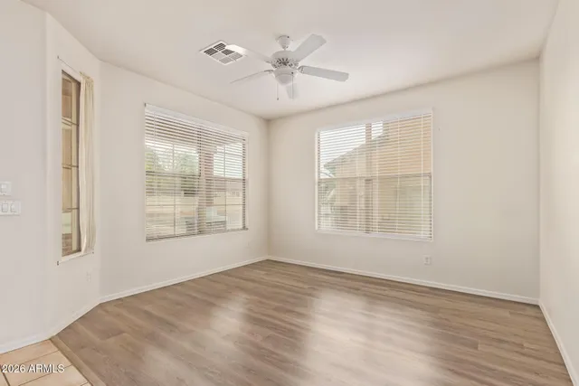 a view of an empty room with a window and wooden floor