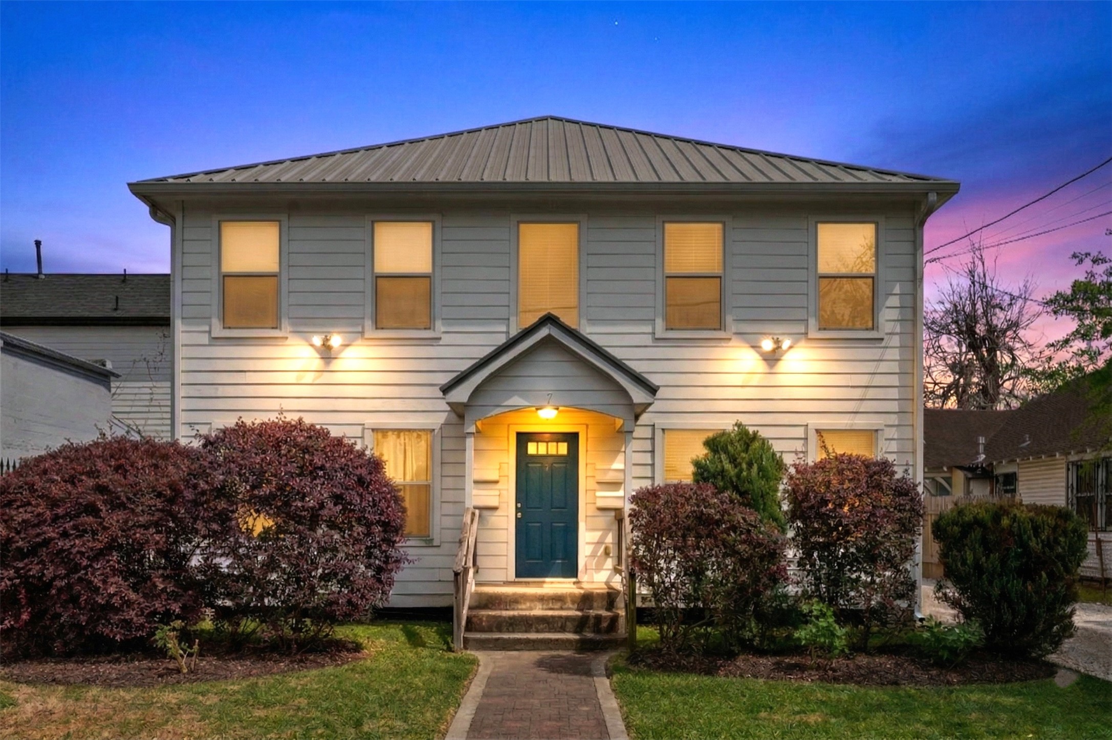 Charming fourplex with a symmetrical façade, mature landscaping, and a welcoming central entry. Plenty of parking, central HVAC, and a metal roof.