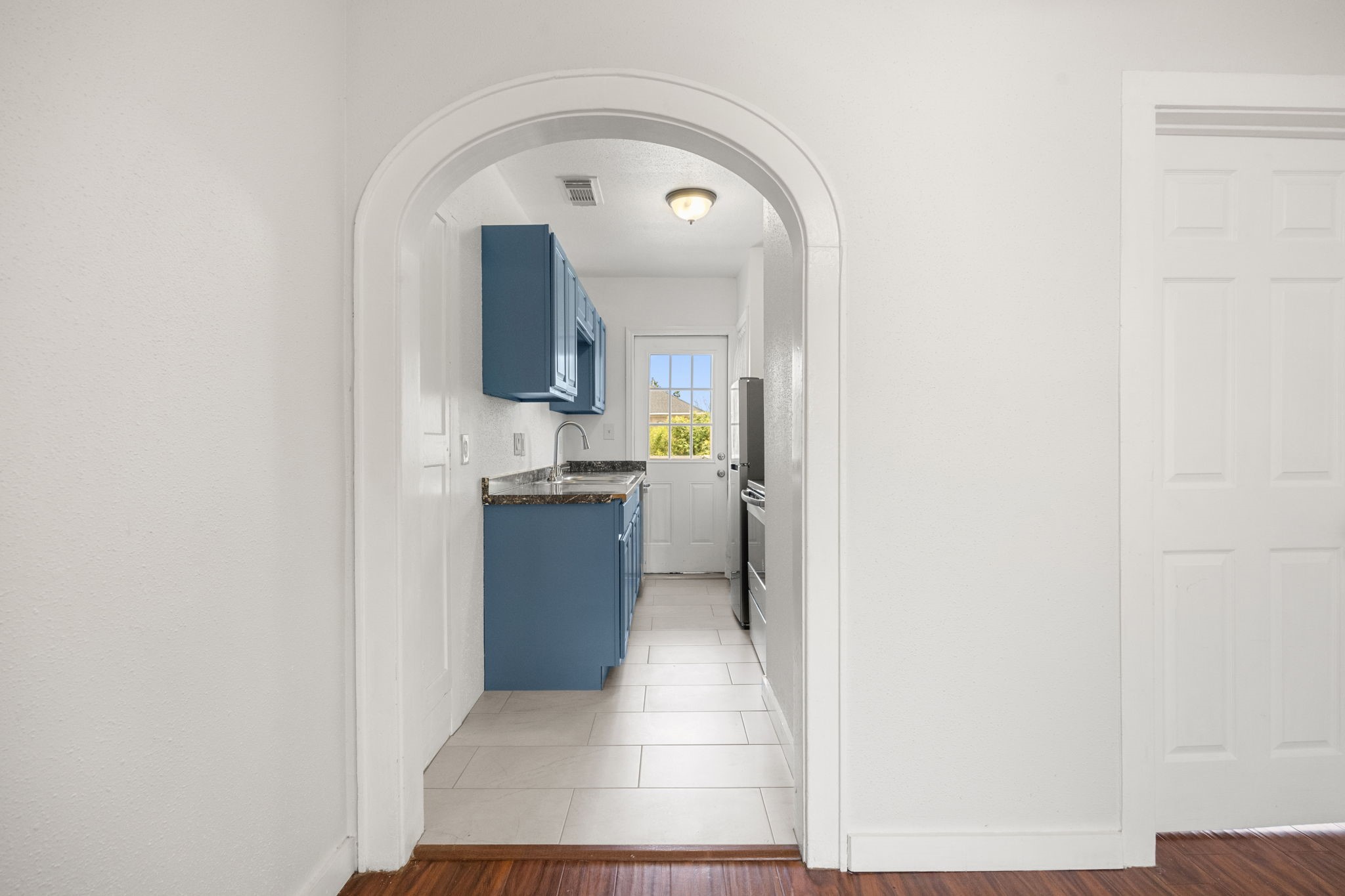 7 Latham Street Houston, TX 77011 - Photo 9 of 23 Elegant arched opening creates a natural transition between living and dining areas, adding architectural character.