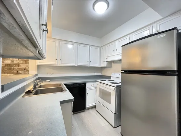 a kitchen with granite countertop a sink stove and refrigerator