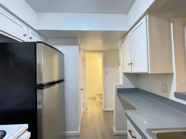 a kitchen with a refrigerator and a stove top oven