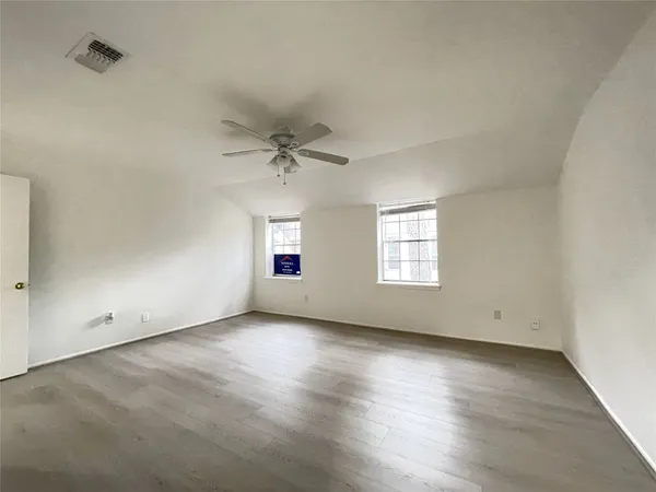 an empty room with wooden floor and entryway