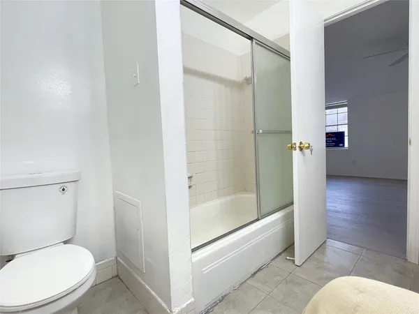 a bathroom with a toilet and a shower
